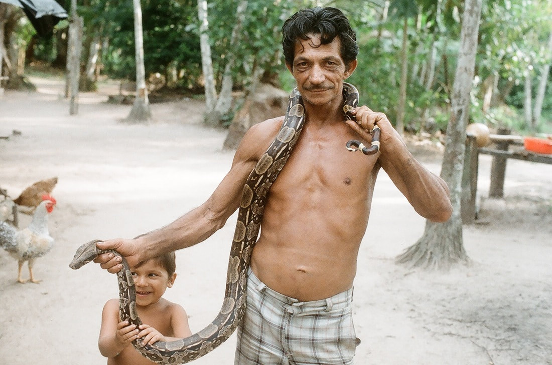 Man with his son and his pet Boa Constrictor, near Belem, Brazil
